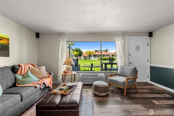 a living room with furniture and a floor to ceiling window