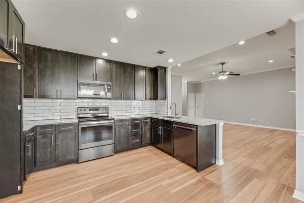 a large kitchen with a stove top oven and sink