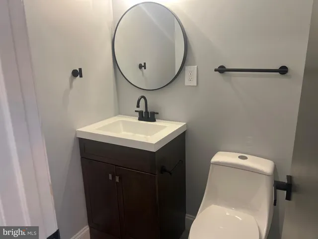 a bathroom with a sink a toilet and a mirror