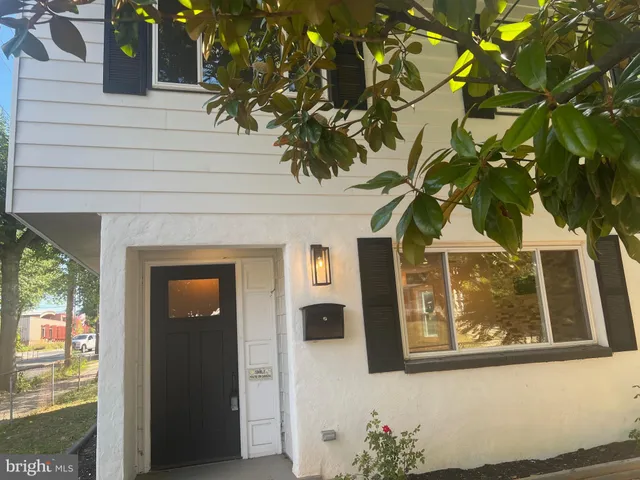 a front view of a house with a tree