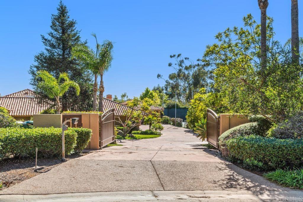 7196 Rancho La Cima Drive Rancho Santa Fe, CA 92067 - Photo 15 of 57 a view of a garden with a bench