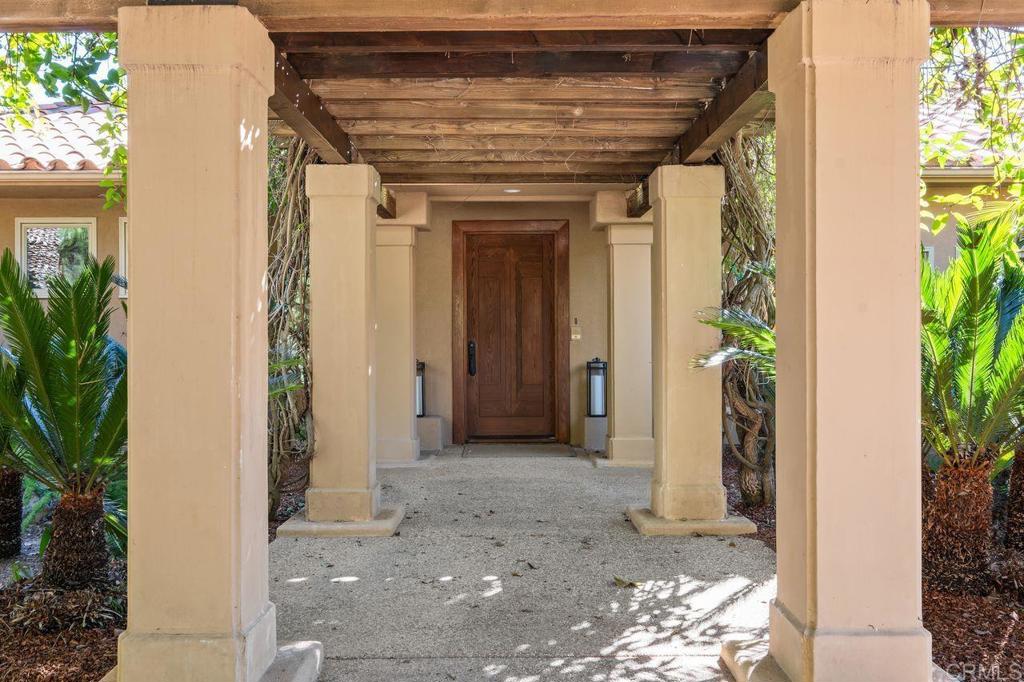 7196 Rancho La Cima Drive Rancho Santa Fe, CA 92067 - Photo 18 of 57 a view of a hallway with potted plants