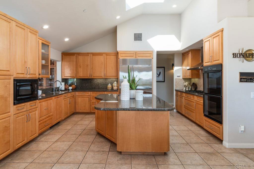 7196 Rancho La Cima Drive Rancho Santa Fe, CA 92067 - Photo 23 of 57 a kitchen with stainless steel appliances granite countertop a refrigerator a oven and a sink