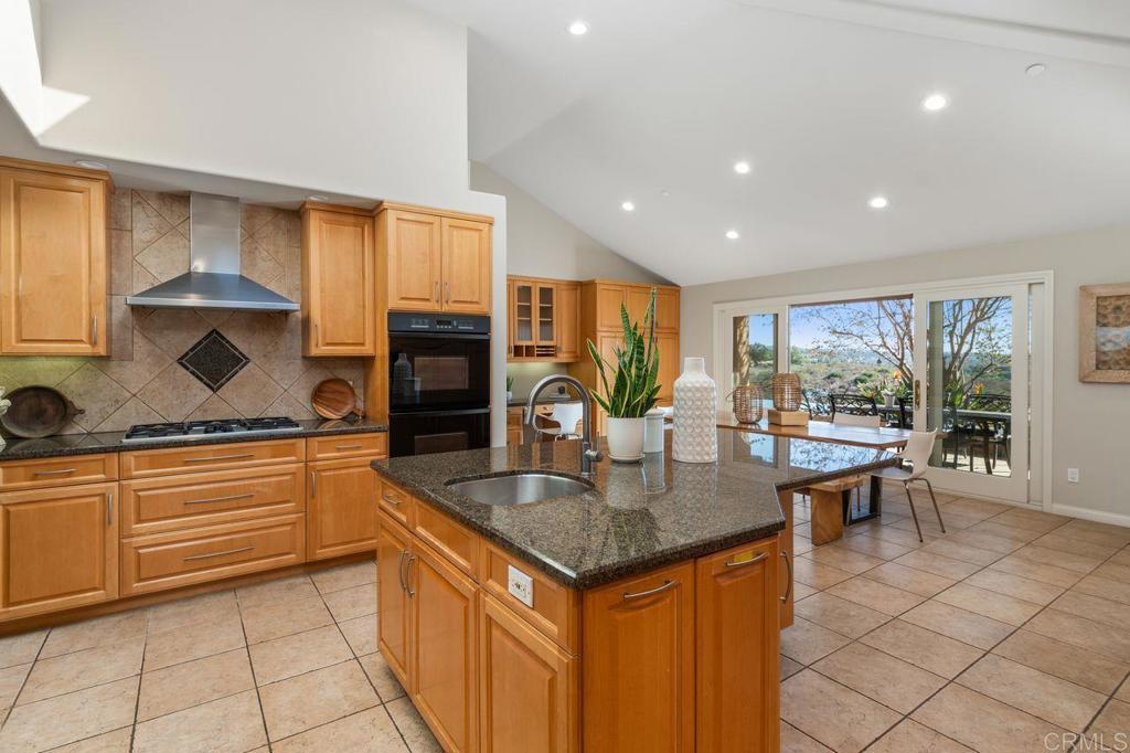 7196 Rancho La Cima Drive Rancho Santa Fe, CA 92067 - Photo 24 of 57 a kitchen with stainless steel appliances granite countertop sink stove and cabinets