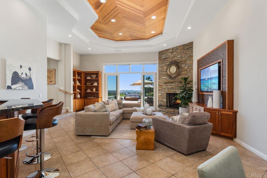 7196 Rancho La Cima Drive Rancho Santa Fe, CA 92067 - Photo 26 of 57 a living room with fireplace furniture and a large window