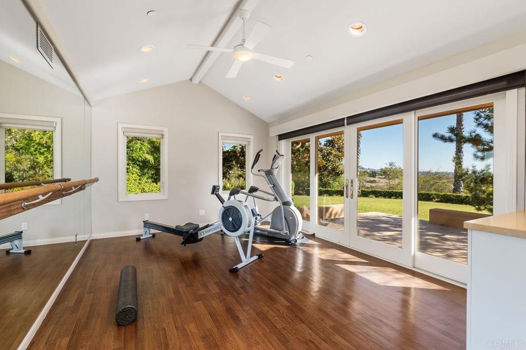 7196 Rancho La Cima Drive Rancho Santa Fe, CA 92067 - Photo 31 of 57 a view of a room with gym equipment and large windows