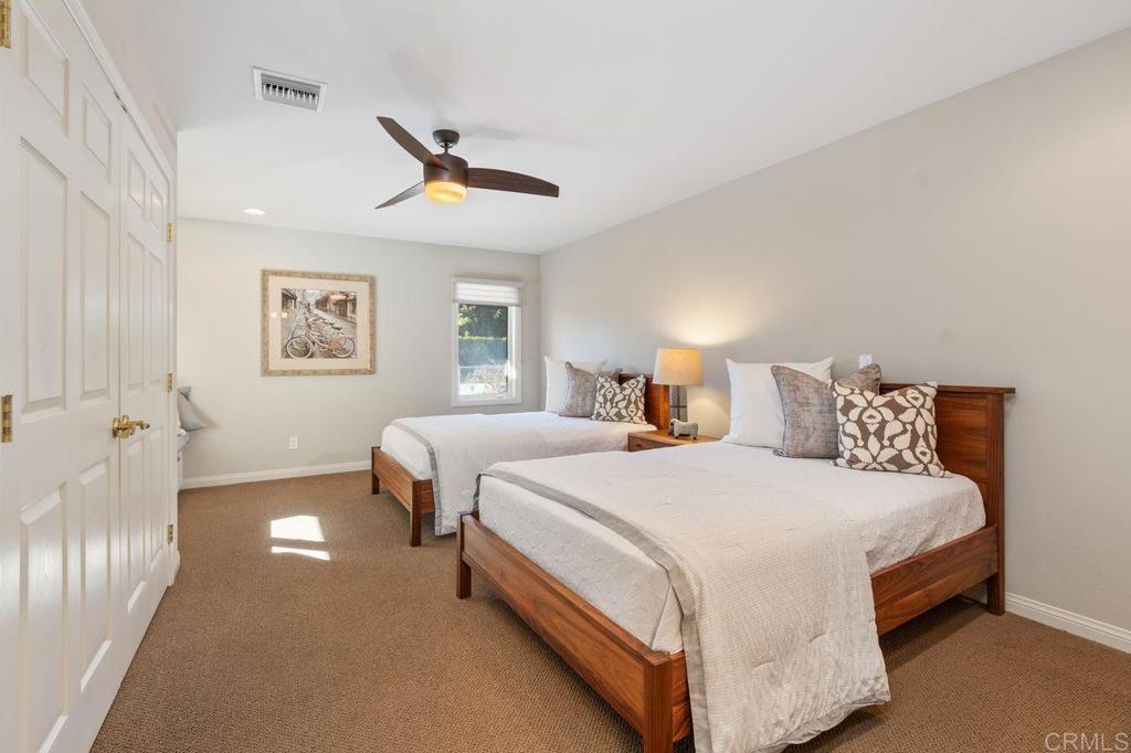 7196 Rancho La Cima Drive Rancho Santa Fe, CA 92067 - Photo 39 of 57 a bedroom with a bed and a chandelier