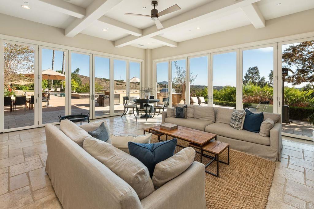 7196 Rancho La Cima Drive Rancho Santa Fe, CA 92067 - Photo 43 of 57 a living room with furniture potted plant and a large window