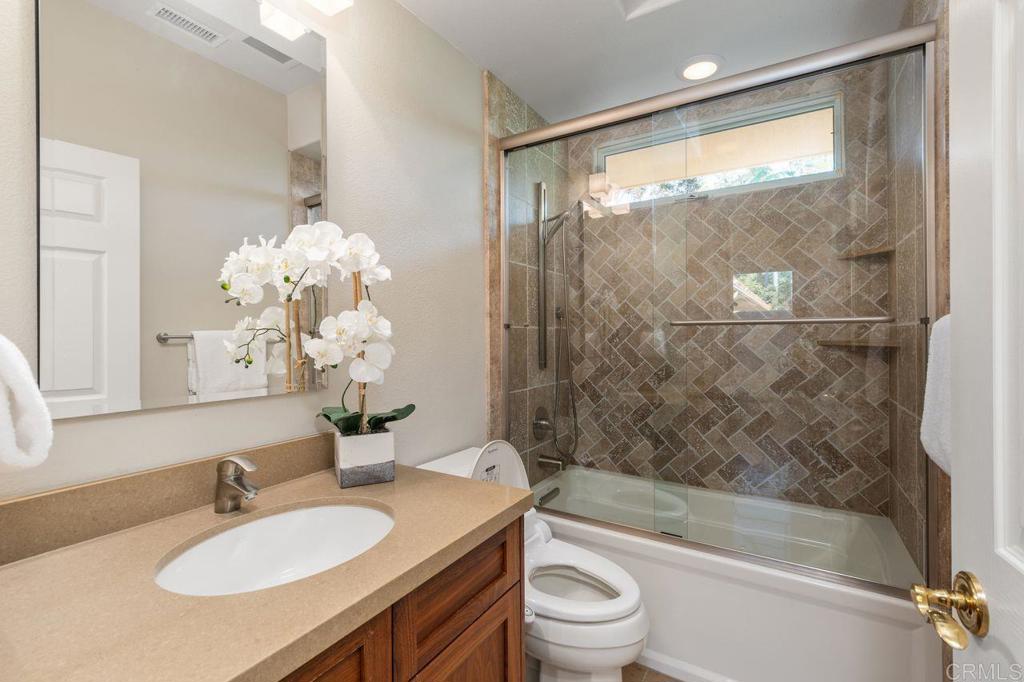 7196 Rancho La Cima Drive Rancho Santa Fe, CA 92067 - Photo 46 of 57 a bathroom with a granite countertop sink toilet and shower