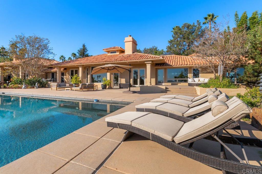7196 Rancho La Cima Drive Rancho Santa Fe, CA 92067 - Photo 53 of 57 a view of a patio with table and chairs potted plants with wooden fence