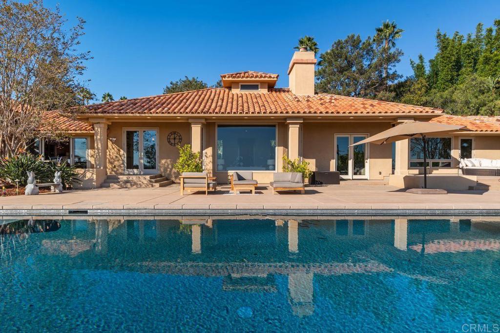 7196 Rancho La Cima Drive Rancho Santa Fe, CA 92067 - Photo 54 of 57 a view of a patio with couches table and chairs with wooden floor and fence