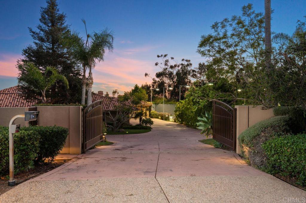 7196 Rancho La Cima Drive Rancho Santa Fe, CA 92067 - Photo 57 of 57 a view of a street with potted plants and large trees