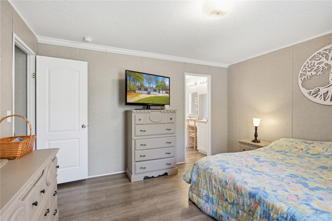 240 Southeast 147 Seneca, SC 29678 - Photo 13 of 26 This bright and inviting bedroom offers a tranquil retreat with practical flooring and direct bathroom access.