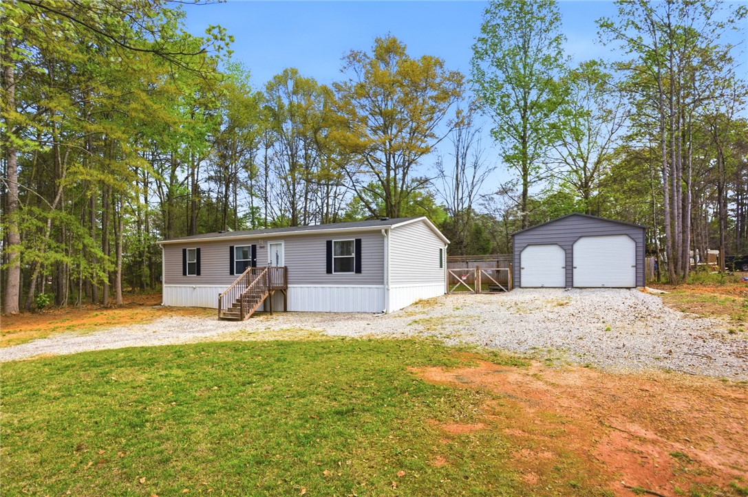 240 Southeast 147 Seneca, SC 29678 - Photo 2 of 26 This charming home features a gravel driveway and a well-maintained exterior with mature trees.