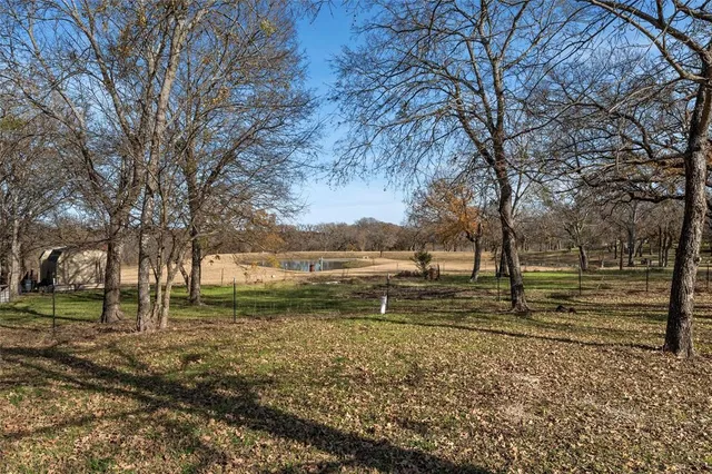 a view of a yard with wooden fence