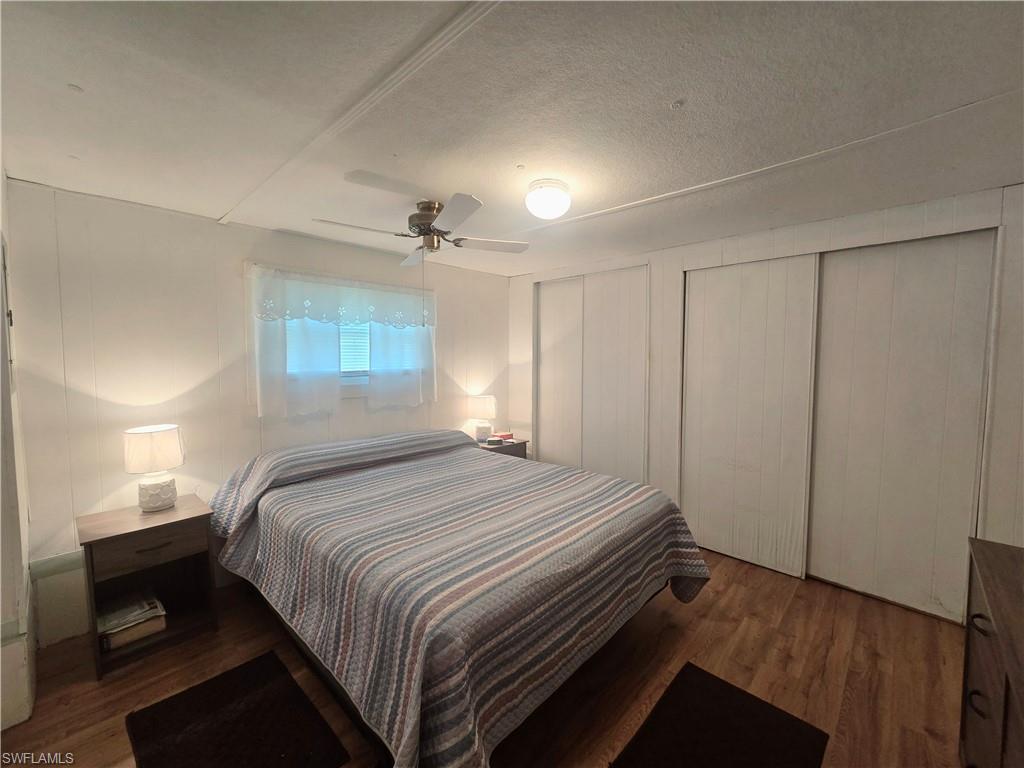 99 Moorhead Manor, Unit 99 Naples, FL 34112 - Photo 14 of 26 a bedroom with a bed and a chandelier