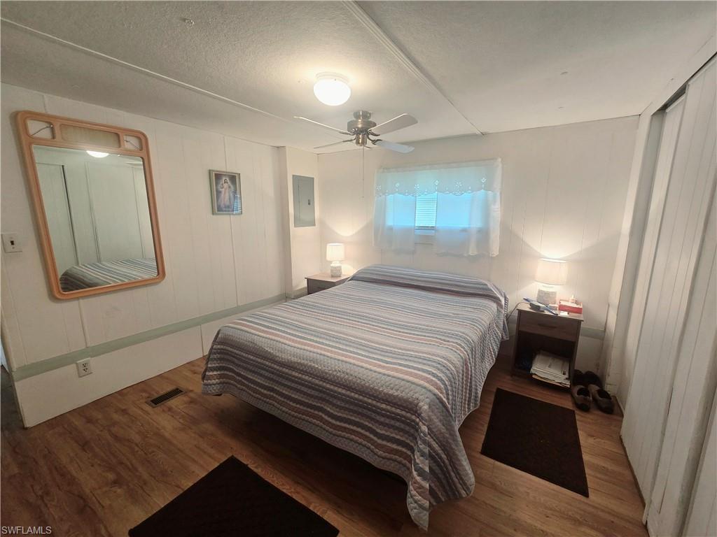 99 Moorhead Manor, Unit 99 Naples, FL 34112 - Photo 15 of 26 a bedroom with a bed and a mirror