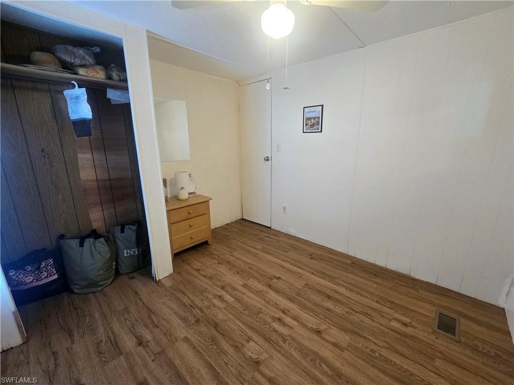 99 Moorhead Manor, Unit 99 Naples, FL 34112 - Photo 18 of 26 a view of an empty room with wooden floor and a window