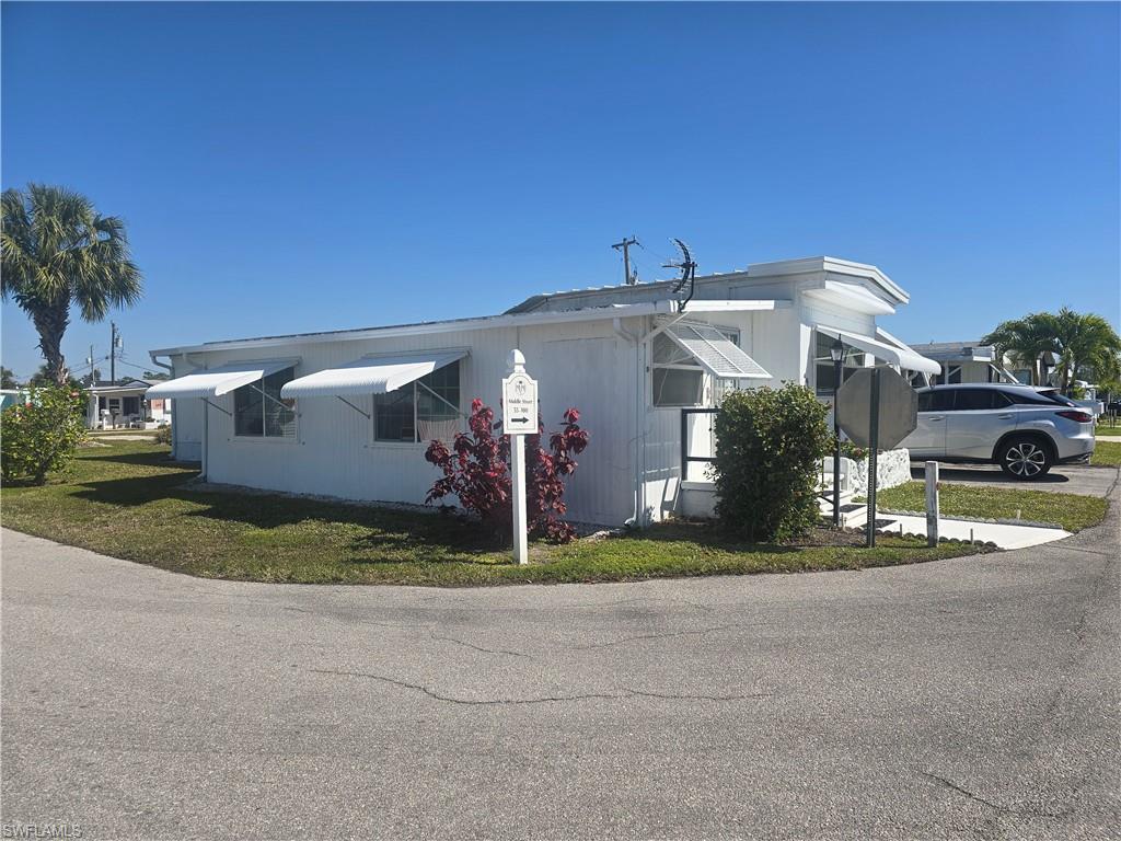 99 Moorhead Manor, Unit 99 Naples, FL 34112 - Photo 2 of 26 a front view of a house with a yard