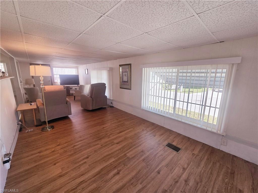99 Moorhead Manor, Unit 99 Naples, FL 34112 - Photo 4 of 26 a living room with furniture and a wooden floor