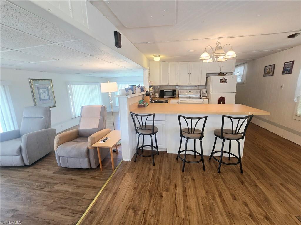 99 Moorhead Manor, Unit 99 Naples, FL 34112 - Photo 8 of 26 a dining room with furniture and wooden floor