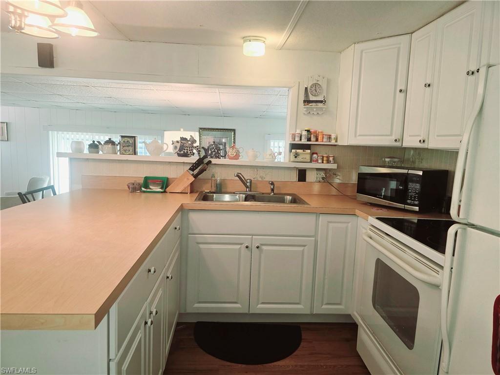 99 Moorhead Manor, Unit 99 Naples, FL 34112 - Photo 10 of 26 a kitchen with a sink and cabinets