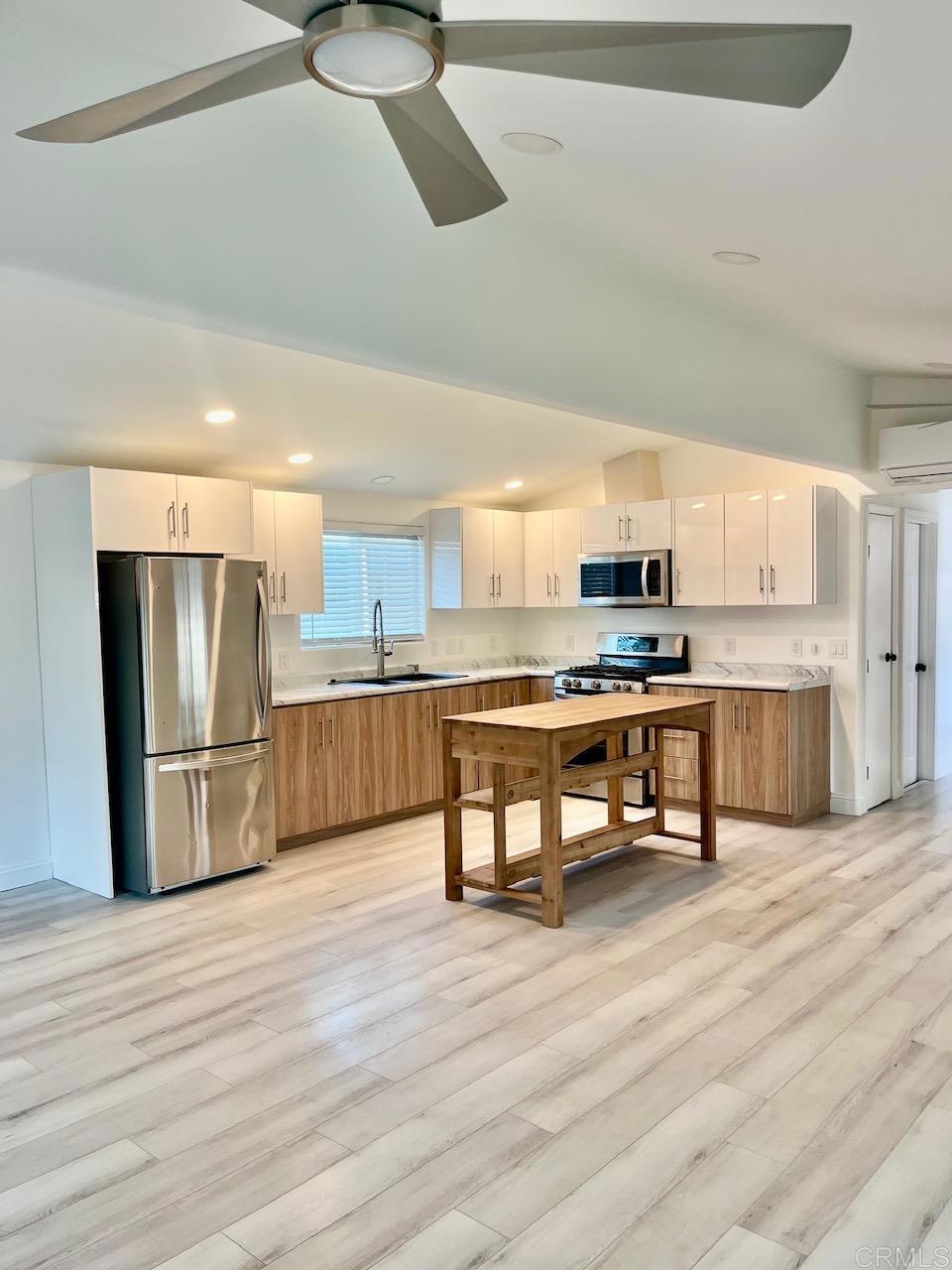 9902 Jamacha Boulevard, Unit 160 Spring Valley, CA 91977 - Photo 5 of 18 a kitchen with stainless steel appliances kitchen island granite countertop a refrigerator and a stove top oven