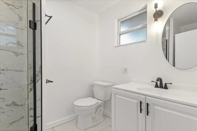 a bathroom with a toilet a sink and mirror