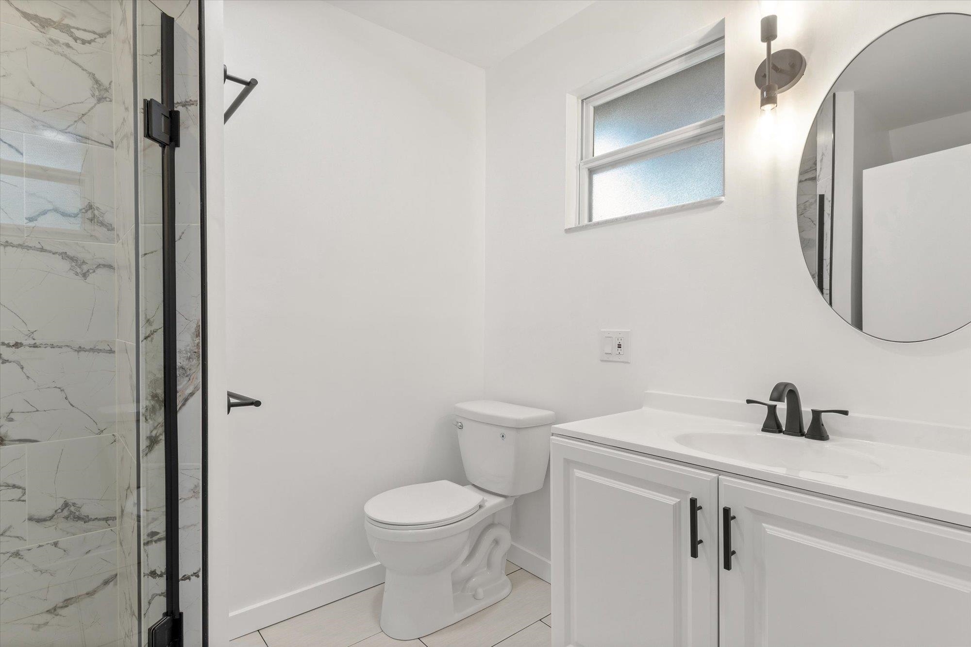 28 Sebastian Avenue, Unit D St. Augustine, FL 32084 - Photo 14 of 23 a bathroom with a toilet a sink and mirror