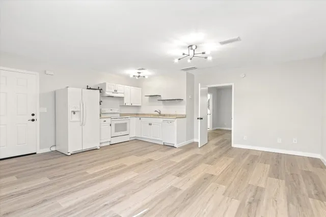 a view of a kitchen with wooden floor and a sink