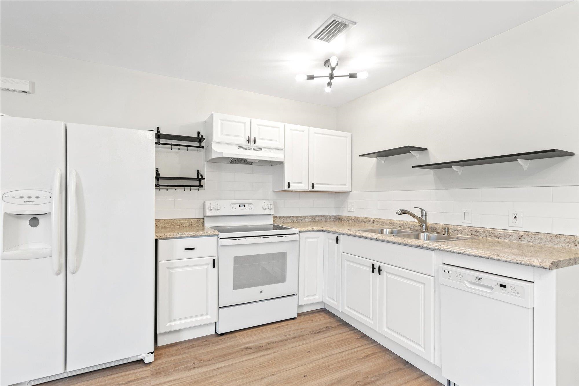 28 Sebastian Avenue, Unit D St. Augustine, FL 32084 - Photo 8 of 23 a kitchen with stainless steel appliances granite countertop a sink a stove a refrigerator and white cabinets