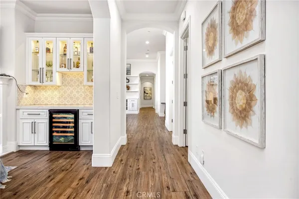 a view of a hallway with wooden floor and windows