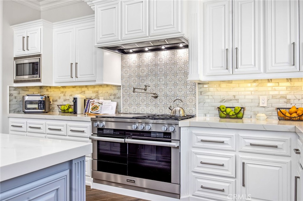 4709 Briana Court Fallbrook, CA 92028 - Photo 16 of 57 a kitchen with stainless steel appliances granite countertop a stove and a white cabinets