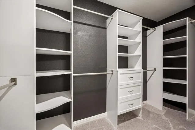a view of closet with cabinets