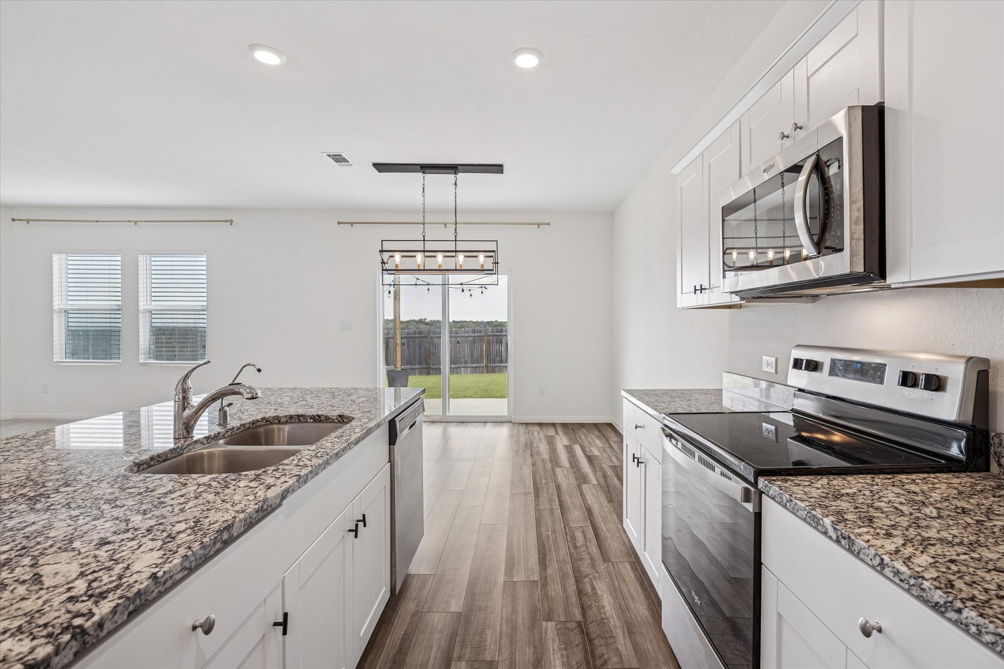 208 Night Riders Way Jarrell, TX 76537 - Photo 4 of 31 a kitchen with stainless steel appliances granite countertop a sink stove and cabinets