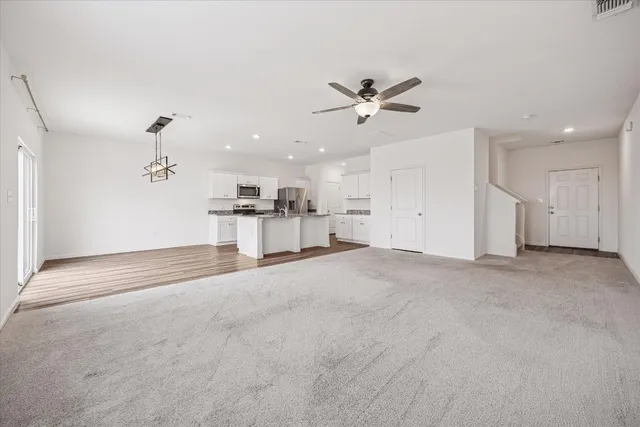 a view of a big room with a ceiling fan and window