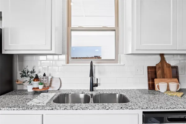 a kitchen with granite countertop a sink and a stove