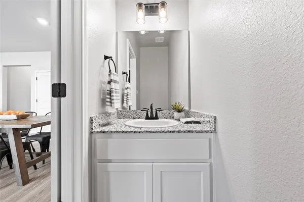 a bathroom with a granite countertop sink and a mirror