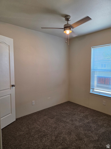 1275 Thrush Road Salt Lake City, UT 84123 - Photo 12 of 20 Carpeted room featuring a ceiling fan, a window and neutral wall tones