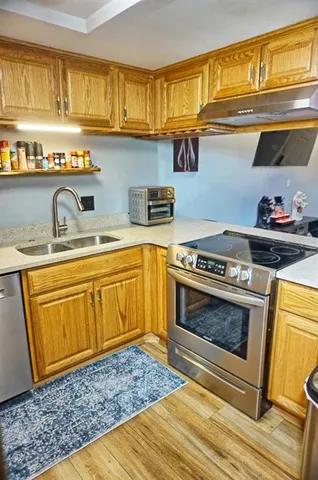 a kitchen with stainless steel appliances granite countertop a sink stove and cabinets