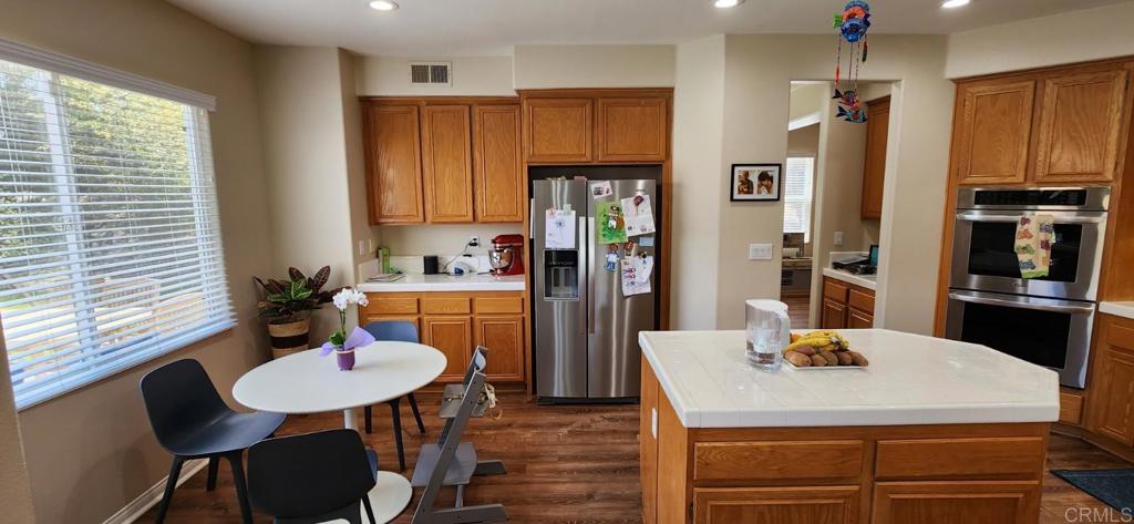 6848 Moorhen Place Carlsbad, CA 92009 - Photo 14 of 53 a kitchen with refrigerator and wooden table