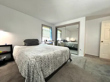a bedroom with a bed and a large mirror