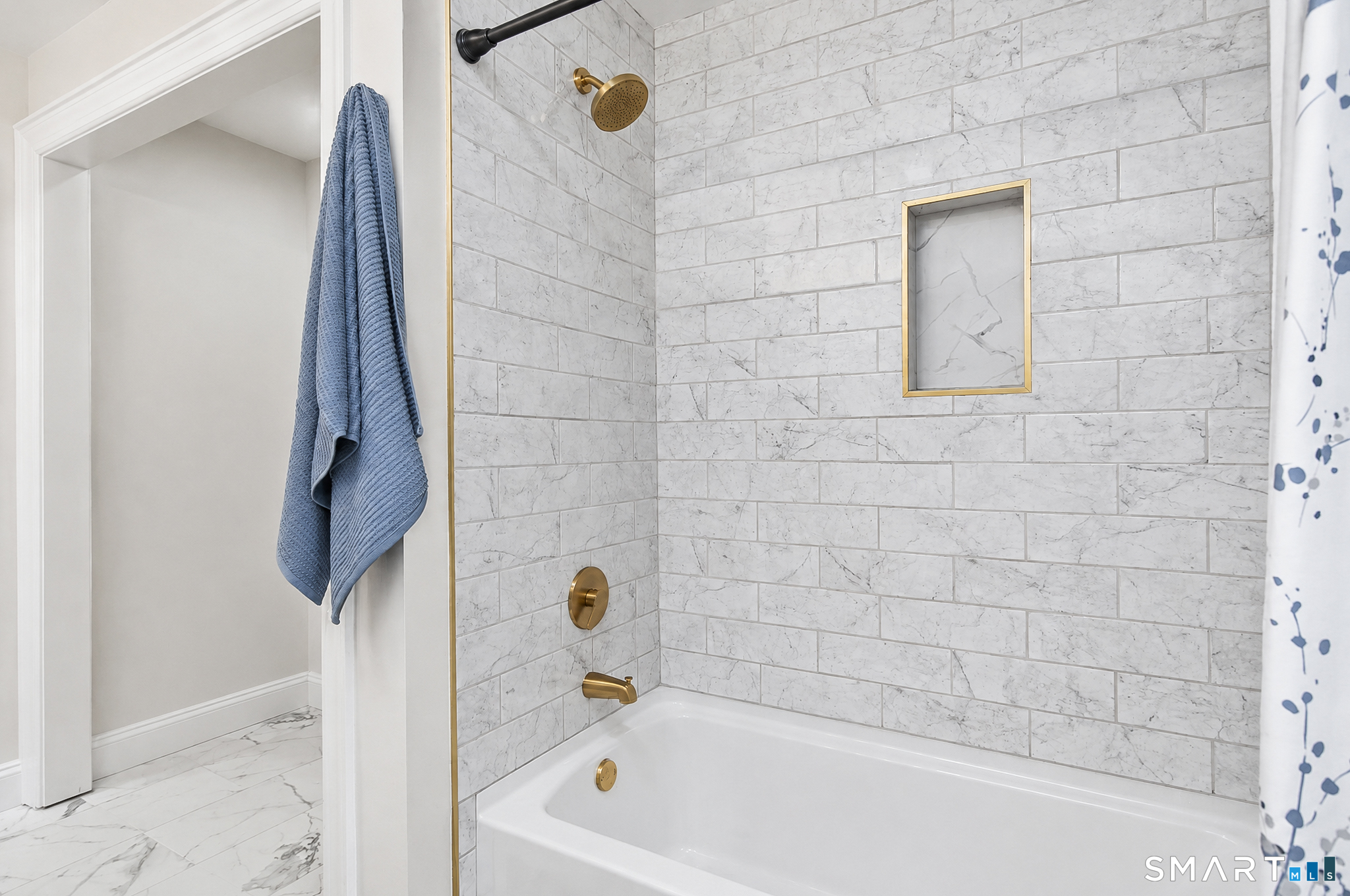 34 Rimmon Road Woodbridge, CT 06525 - Photo 21 of 40 Beautifully updated bath with marble-look tile, tub/shower combination and warm brass fixtures.