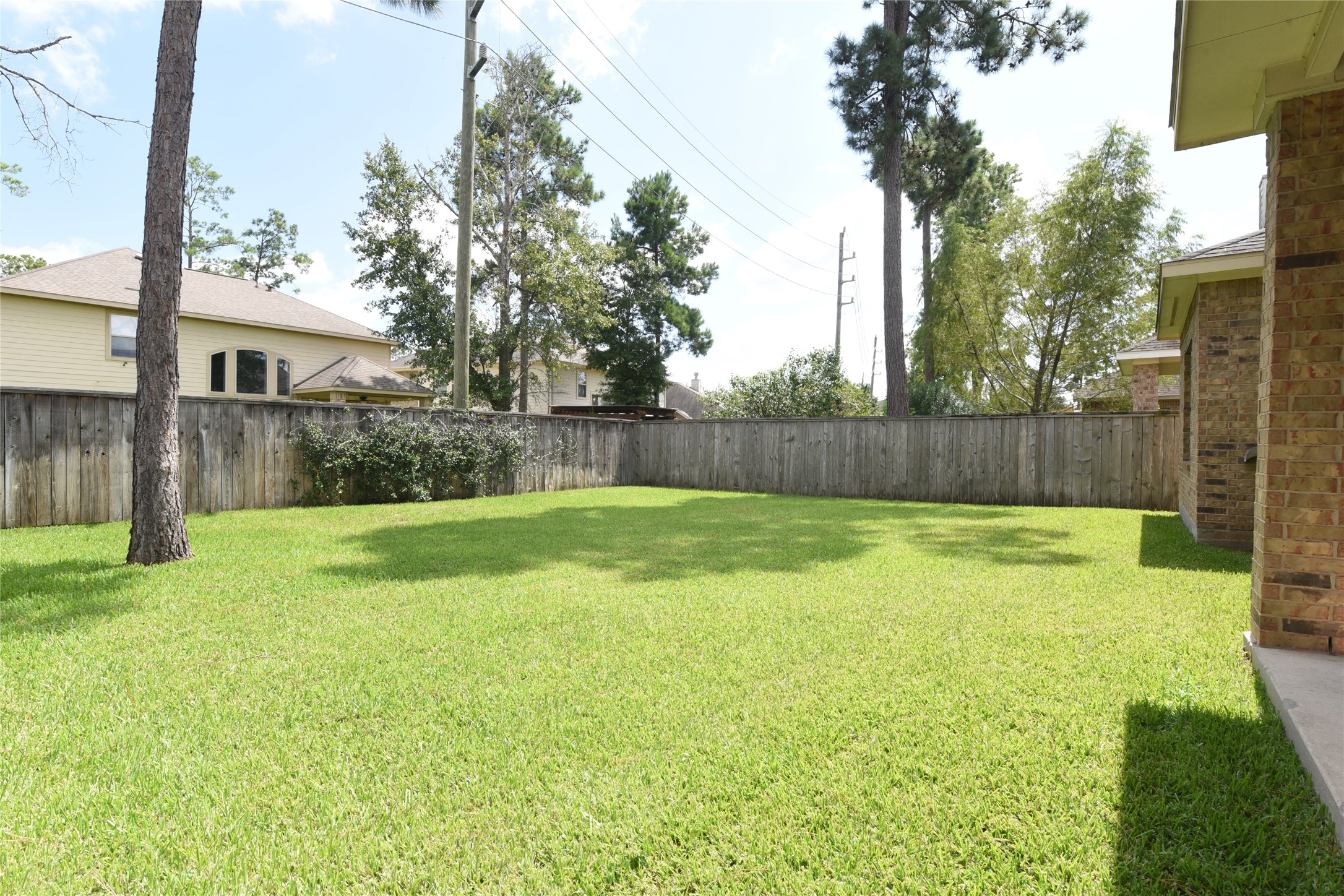118 East Lasting Spring Circle Spring, TX 77389 - Photo 44 of 46 Expansive and well-maintained backyard featuring lush green grass, perfect for outdoor activities and relaxation, all enclosed by a wooden fence for privacy.