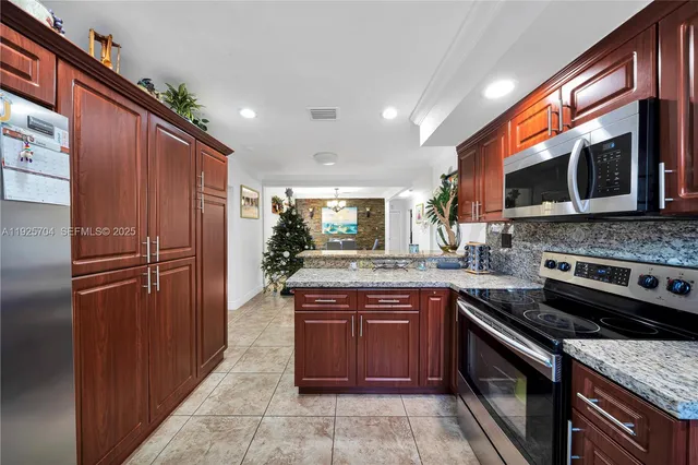 a kitchen with stainless steel appliances granite countertop a refrigerator and a sink