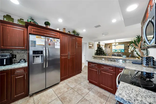 a kitchen with stainless steel appliances granite countertop a refrigerator and a sink