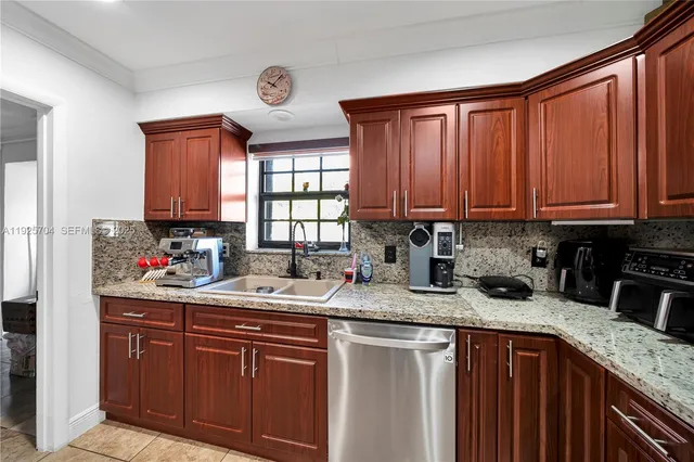 a kitchen with stainless steel appliances granite countertop a sink dishwasher stove and cabinets