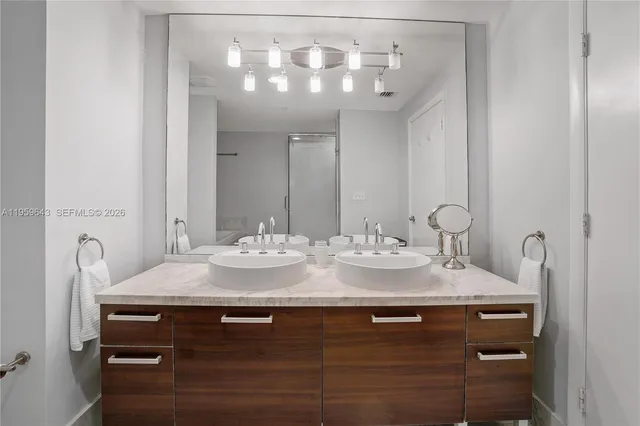 a bathroom with a granite countertop sink a large mirror and vanity