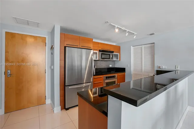 a kitchen with stainless steel appliances granite countertop a refrigerator and a sink