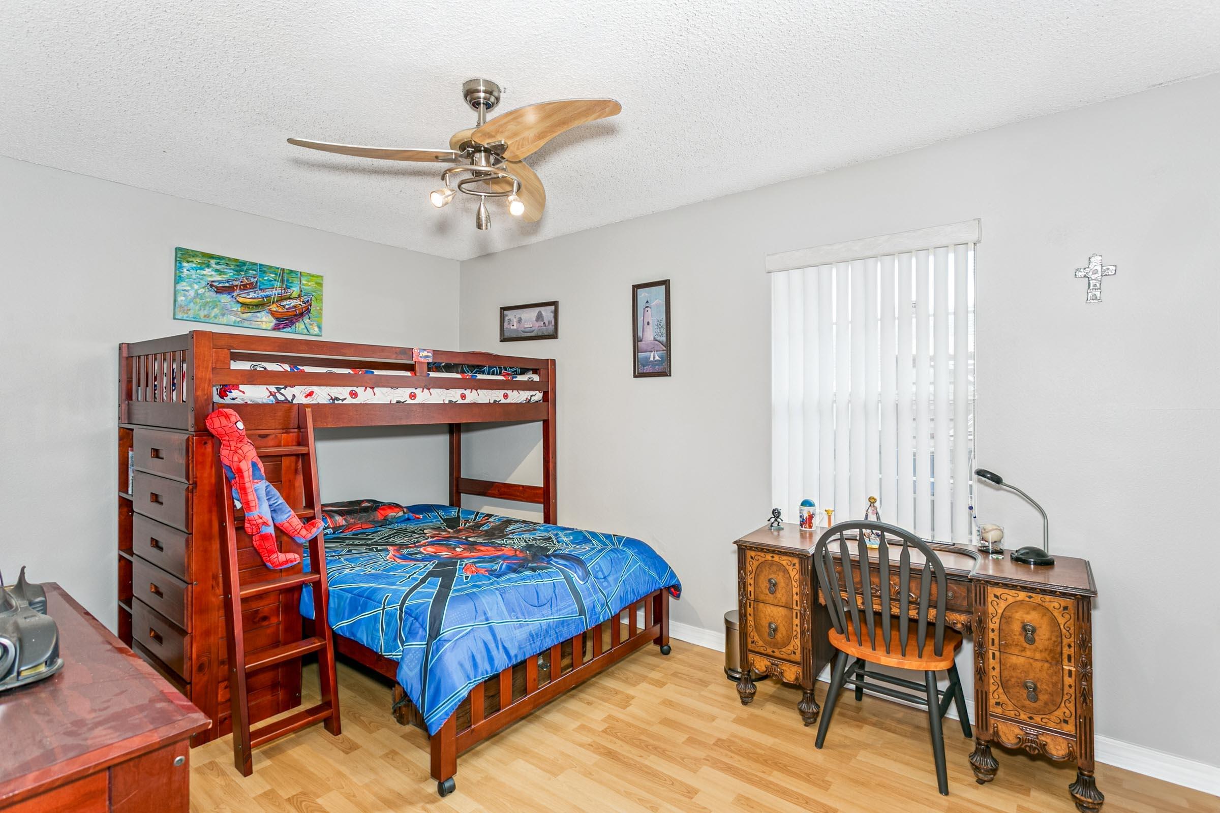 2246 Titanium Drive Crestview, FL 32536 - Photo 17 of 38 a bedroom with a bed and a table in it